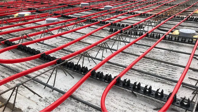 Verlegte rote Kunststoffrohre zur Betonkernaktivierung, fixiert vor dem Betonieren.