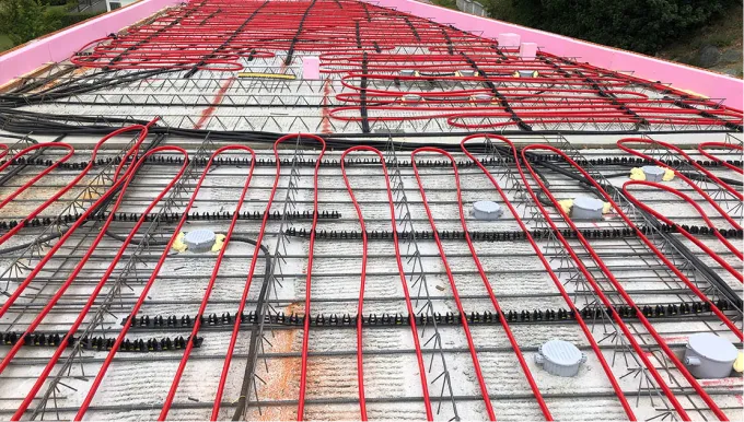 Verlegte rote Kunststoffrohre zur Betonkernaktivierung, fixiert vor dem Betonieren.