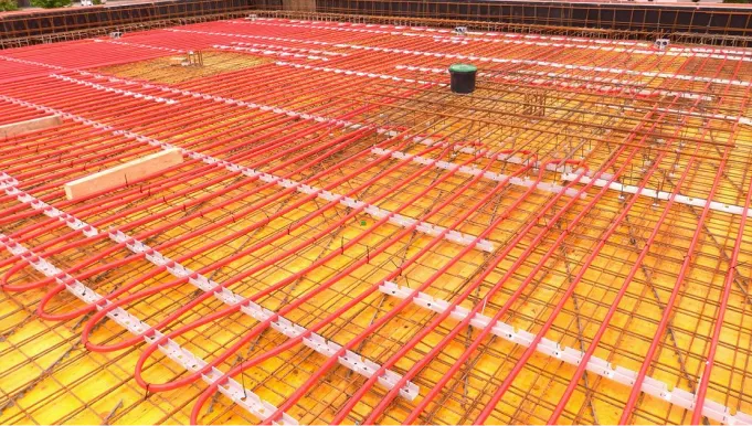 Verlegte rote Kunststoffrohre zur Betonkernaktivierung, fixiert vor dem Betonieren.