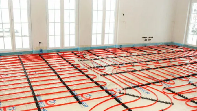 Verlegte rote Kunststoffrohre für die Fußbodenheizung, fixiert zur Installation