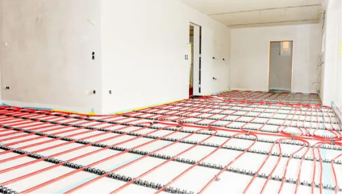 Verlegte rote Kunststoffrohre für die Fußbodenheizung, fixiert zur Installation
