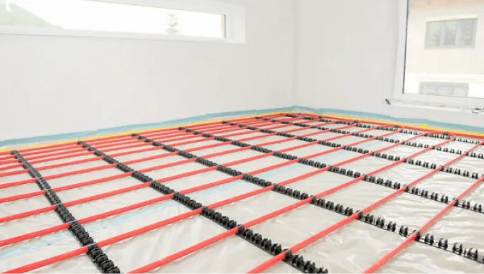 Verlegte rote Kunststoffrohre für die Fußbodenheizung, fixiert zur Installation