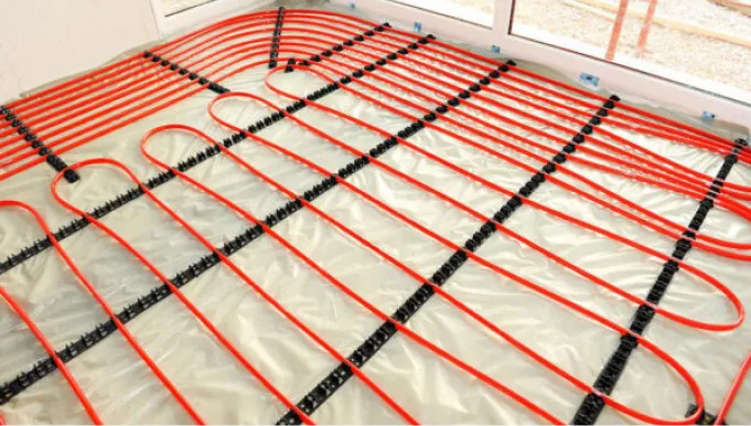 Verlegte rote Kunststoffrohre für die Fußbodenheizung, fixiert zur Installation