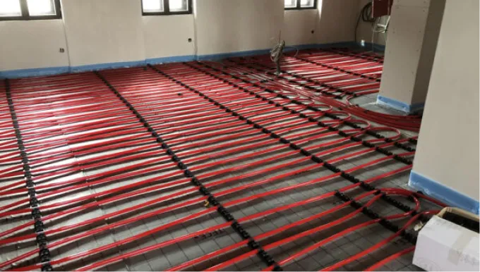 Verlegte rote Kunststoffrohre für die Fußbodenheizung, fixiert zur Installation