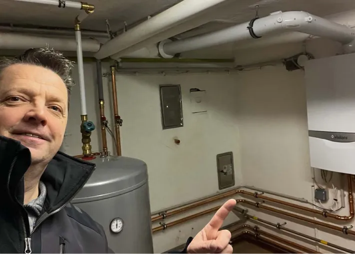 Ewald Janska zeigt stolz auf ein Gasbrennwertgerät