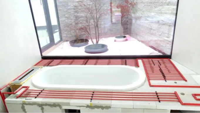 Aufbau der Heizung mit sichtbaren Heizrohren rund um die Badewanne im Badezimmer