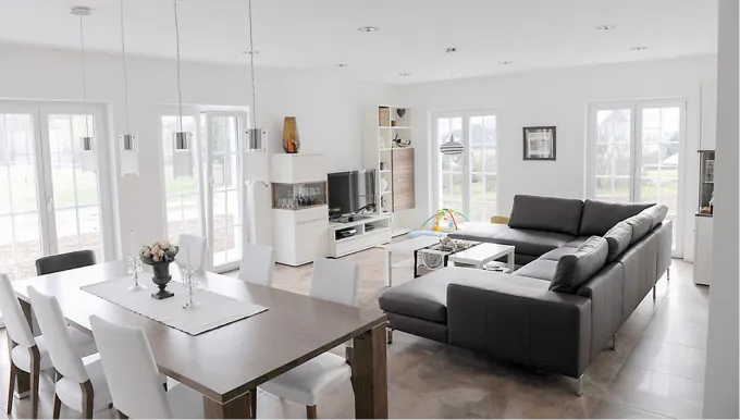 Modernes Wohnzimmer mit Essbereich, beheizt durch eine unsichtbare Wandheizung für höchsten Wohnkomfort.